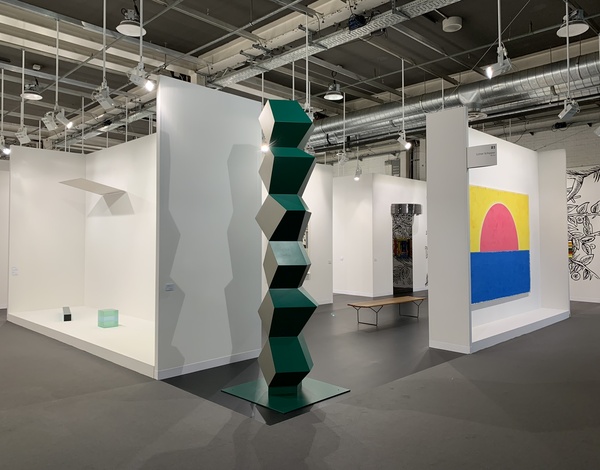artistic dark green cube sculpture between white exhibition walls in event hall with dark grey Rewind carpet