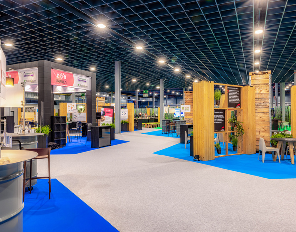 Exhibition stands at VIV Europe inside of Jaarbeurs Utrecht event hall with latex-free carpet pathing in grey and blue
